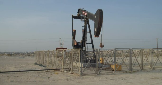 Single oil pump behind fence in desert area close in Riffa