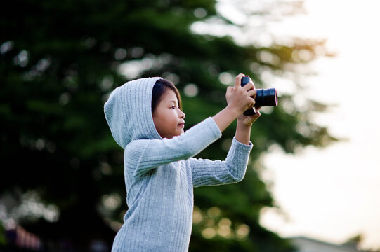 Take pictures with a mirrorless camera. Little girl practicing nature photography little photographer the joy of taking pictures