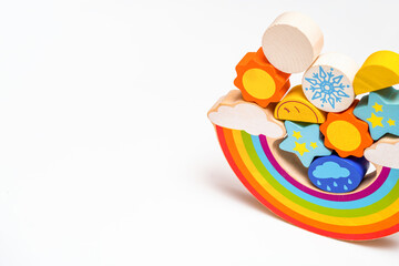 Kids toys. Children's wooden toy in the form of a rainbow. Colorful educational logic wooden toys on white background. Montessori Games. Child Development. Weather. Copy space