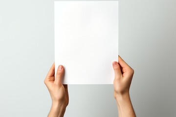 Empty canvas held Hands clutch blank paper, set against a white isolation - obrazy, fototapety, plakaty