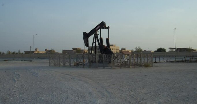 Oil pump in desert area close to buildings in Riffa