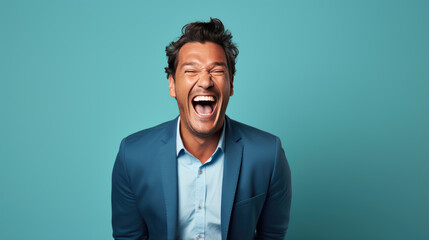 Young man laughs against a blue background. - obrazy, fototapety, plakaty