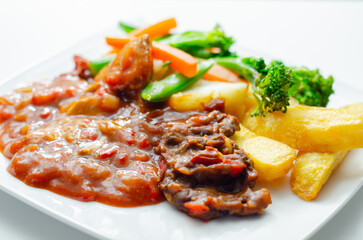 Pulled pork in barbecue style sauce with barbecues style beans with spiced chips and fresh vegetables