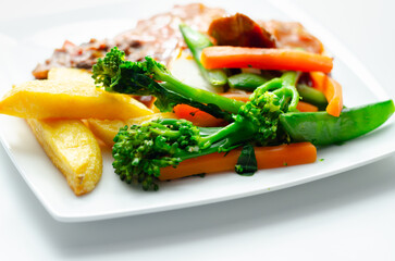 Pulled pork in barbecue style sauce with barbecues style beans with spiced chips and fresh vegetables