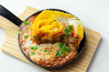 Hand rolled four cheese ravioli pasta in minced beef with Chianti red wine, garlic and herb ragu, and a bechamel sauce topped with pecorino cheese crumb and finished with fresh parsley