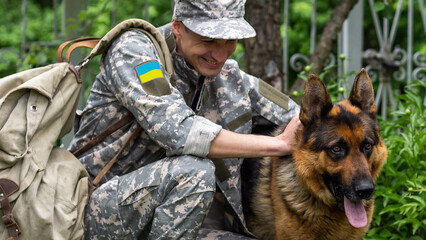 A Ukrainian soldier in military uniform with dog, yellow and blue flag.