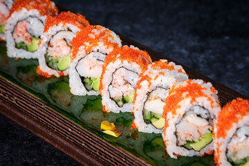 Delicious sushi rolls reflecting in Japanese wooden dishware