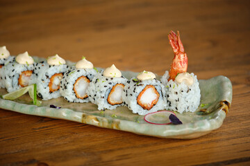 Delicious sushi rolls on plate placed on table