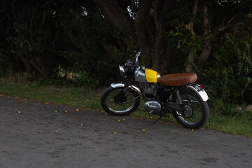 Obraz premium Yellow and chrome vintage motor bike on the side of the road, during warm late summer in Denmark