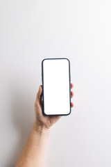 Vertical image of caucasian woman holding smartphone with blank screen on white background