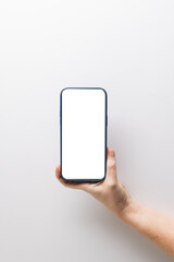 Vertical image of caucasian woman holding smartphone with blank screen on white background