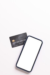 Vertical image of smartphone with blank screen and credit card on white background