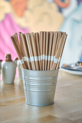 Chopsticks in bucket on table