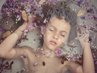 Boy in bathtub with flowers