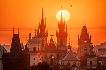 A rising sun behind towers of the Church of Our Lady before Tyn in Prague. - obrazy, fototapety, plakaty