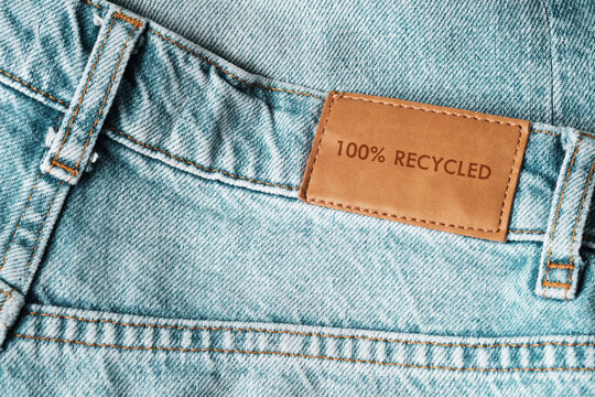 Jeans labeled 100% recycled. Sustainable fashion, conscious consumption.