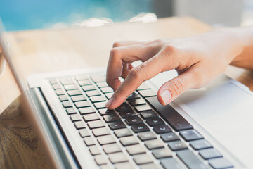 Close up fingers typing on the computer keyboard,pressing buttons, typing, simple close up with lens flare