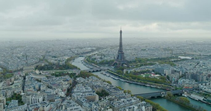 Beautiful view of famous Eiffel Tower in France with magical morning cloud and fog. Wide establishing aerial drone fly over seine river in paris city center, best travel destination landmark in Europe