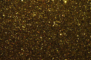 Golden defocused glitter texture as background
