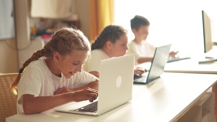 children learn from home through computers. business concept of modern training and development. a group of little kids perform tasks in a lifestyle laptop at home schooling. educating from home