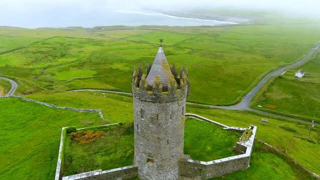 Aerial foggy view of Doonagore Castle, iconic landmark, County Clare, Ireland