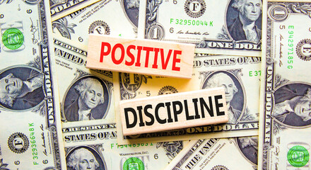 Positive discipline symbol. Concept words Positive discipline on beautiful blocks. Dollar bills. Beautiful background from dollar bills. Business psychology positive discipline concept. Copy space.