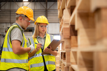 Both of workers work in a woodworking factory, Checking inventory the wood in the wooden warehouse