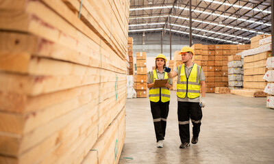 Both of workers work in a woodworking factory, Checking inventory the wood in the wooden warehouse - obrazy, fototapety, plakaty
