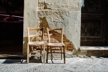 Pienza, Tuscany: two chairs with straw seats along the street in the historic centre