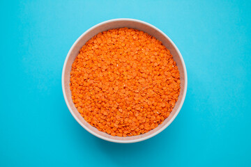 uncooked Red lentils in white bowl on ceramic