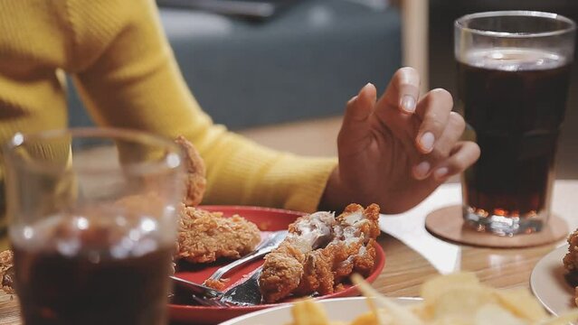 Closeup image of a beautiful asian woman enjoy eating french fries and fried chicken in restaurant