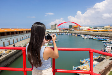 Woman use digital camera to take photo in Zhuwei Fish Harbor in Taoyuan of Taiwan
