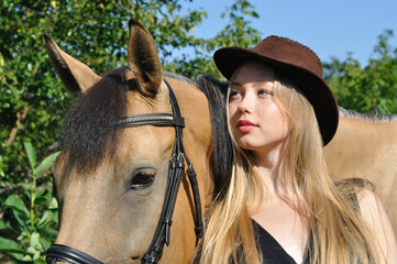 Fototapeta premium portrait of teenage girl and horse in summer day