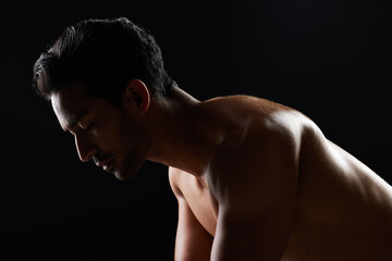 Exercise, strong and studio man doing push up challenge, gym fitness routine and workout for muscle building. Dark shadow light, body training development and calm sports athlete on black background
