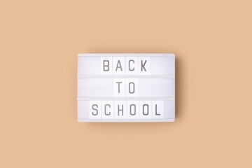 Back to school. White lightbox with letters on a beige background.
