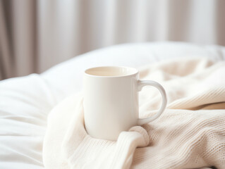 Fototapeta na wymiar Blank empty white coffee mug mockup on warm knitted clothes in autumn and winter season