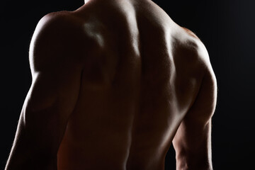 Fototapeta na wymiar Bodybuilder man, back and silhouette in studio, shadow and wellness with health, strong and black background. Model guy, muscle and shirtless for fitness with skin, aesthetic or power in dark for art