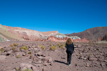 woman black dressed walking to the rocks of valle arcoiiris, antofagasta, atacama, chile