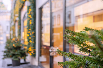 Street in big city is decorated for New Year and Christmas holidays.Branch of Christmas tree. Bokeh in background. Out of focus. Without people.