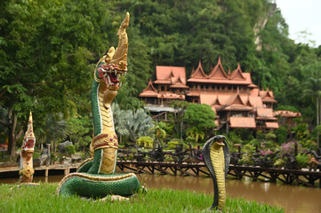 Serpent statue front of Thai houses decorated at Tham Khao Wong Temple. To allow Buddhists and...