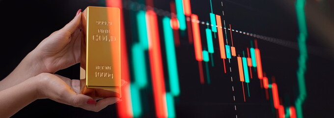 Girl holding gold bar , Business graph background . Buying gold investment