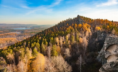 Autumn landscape from the top of a mountain with a lake, trees, mountains and sky