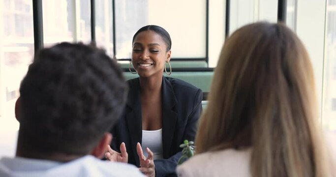 35s African businesswoman manager consults, handshake clients make insurance, bank loan deal at formal meeting. Female applicant talking to HR shake hand of recruiter get hired finish job interview