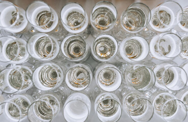 Glass wine glasses with champagne stand in a row on a table in a bar at a banquet. Close-up photo of food, top view.
