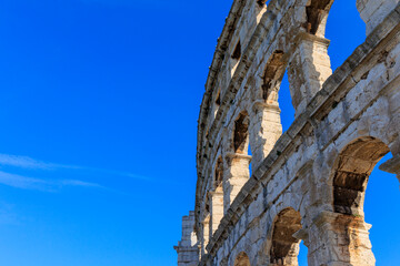 The ruins of the Roman arena in the Croatian city of Pula under a blue sky on a sunny day