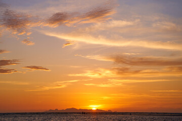 Incredible colors of the sunset sky with marshmallow clouds over the ocean