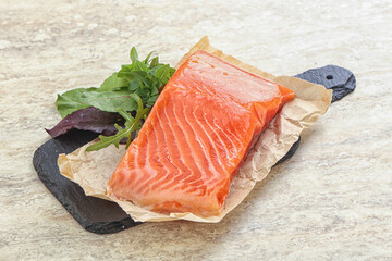 Raw salmon fillet over board