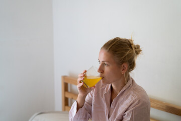 Woman drinking from a glass with the dissolved vitamins