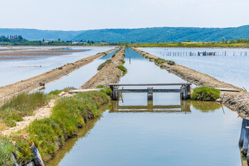 A view down water channels beside the crystallisation pools at the salt pans at Secovlje, near to...