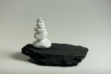 white smooth stones balanced over one black flat stone  - 640817304